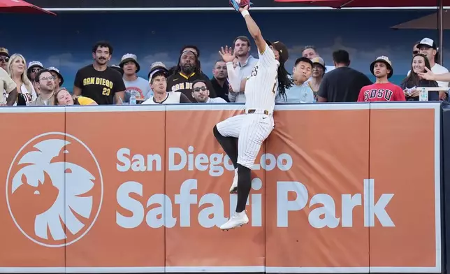 San Diego Padres right fielder Fernando Tatis Jr. makes the catch above the wall for the out on a sacrifice fly by San Francisco Giants' Rafael Devers during the first inning of a baseball game Thursday, July 30, 2026, in San Diego. (AP Photo/Gregory Bull)
