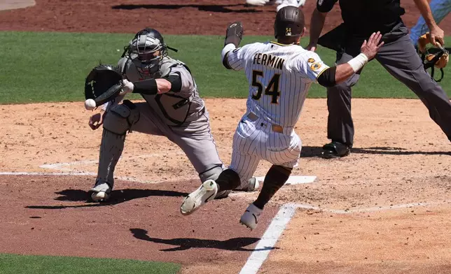 Colorado Rockies catcher Brett Sullivan, left, waits for the throw before tagging out San Diego Padres' Freddy Fermin (54), trying to score from third during the fifth inning of a baseball game Wednesday, July 29, 2026, in San Diego. (AP Photo/Gregory Bull)