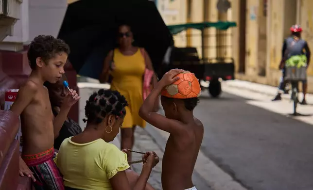 People spend time outside during a blackout in Havana, Cuba, Tuesday, July 14, 2026. (AP Photo/Ramon Espinosa)