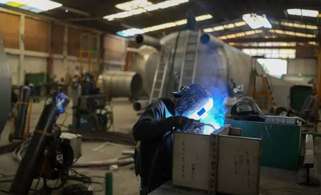 FILE - An employee welds metal at a steel tank factory in Mexico City, Feb. 11, 2025. (AP Photo/Eduardo Verdugo, File)