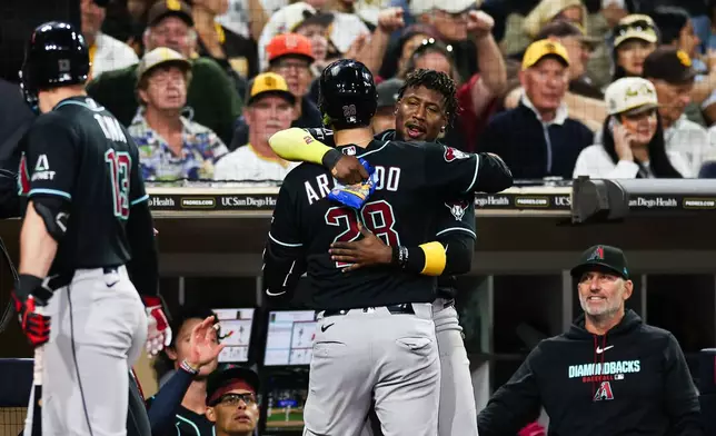 Arizona Diamondbacks' Geraldo Perdomo, second from right, congratulates Nolan Arenado (28) as manager Torey Lovullo, right, watches after Arenado hit a solo home run against the San Diego Padres in the sixth inning of a baseball game Thursday, July 9, 2026, in San Diego. (AP Photo/Derrick Tuskan)