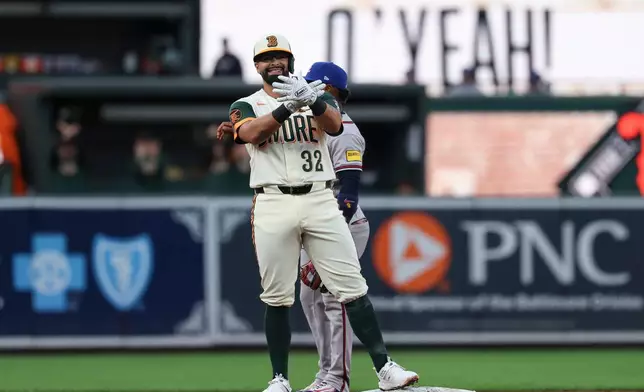 Baltimore Orioles' Christian Encarnacion-Strand (32) gestures toward his dugout after hitting a double off Atlanta Braves pitcher Grant Holmes which scored Leody Taveras and Jackson Holliday during the second inning of a baseball game, Friday, July 24, 2026, in Baltimore. (AP Photo/Terrance Williams)