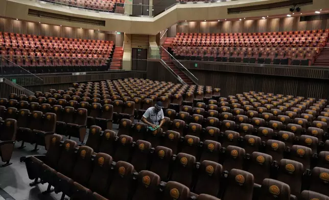 A janitor wipes chairs at the Universidad Santiago de Cali auditorium, where President-elect Abelardo de la Espriella will be inaugurated, in Cali, Colombia, Wednesday, July 29, 2026. (AP Photo/Santiago Saldarriaga)