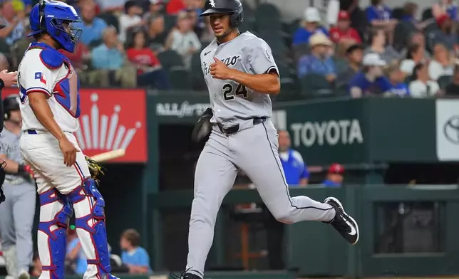Chicago White Sox's Braden Montgomery (24) scores on a single by teammate Andrew Benintendi past Texas Rangers catcher Elias Díaz during the fourth inning of a baseball game, Wednesday, July 22, 2026, in Arlington, Texas. (AP Photo/LM Otero)
