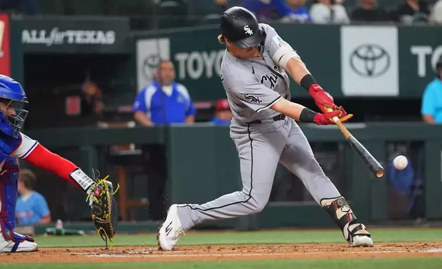 Chicago White Sox's Chase Meidroth, right, hits a run scoring single in front of Texas Rangers catcher Elias Díaz during the second inning of a baseball game, Wednesday, July 22, 2026, in Arlington, Texas. (AP Photo/LM Otero)