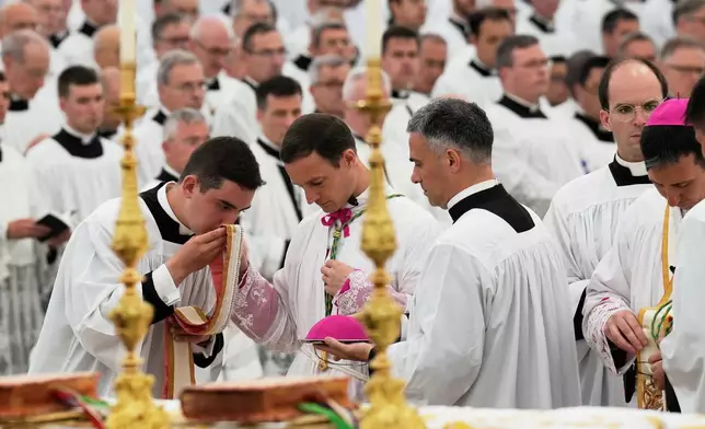 Father Marc Hanappier, center, attends his consecration ceremony as bishop in a tent set up outside the Society of St. Pius X seminary, in Econe, Switzerland, Wednesday, July 1, 2026. (AP Photo/Baz Ratner)