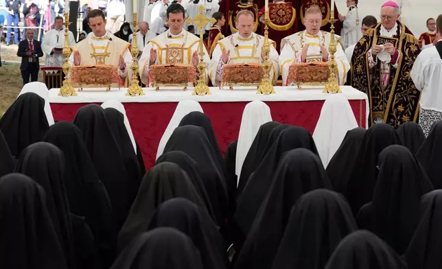 From left Marc Hanappier, Michel Poinsinet de Sivry, Michael Goldade and Pascal Schreiber pray during their consecration ceremony as bishops in a tent set up outside the Society of St. Pius X seminary, in Econe, Switzerland, Wednesday, July 1, 2026. (AP Photo/Baz Ratner)