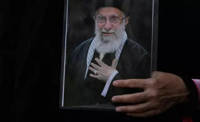 A woman holds a poster of the late Iranian Supreme Leader Ayatollah Ali Khamenei during his funeral procession in Tehran, Iran, Monday, July 6, 2026. (AP Photo/Vahid Salemi)