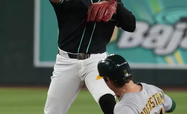 Arizona Diamondbacks second baseman Ildemaro Vargas turns the double play while avoiding Athletics' Tyler Soderstrom (21) on a ball hit by Jonah Heim in the third inning of a baseball game, Tuesday, July 21, 2026, in Phoenix. (AP Photo/Rick Scuteri)