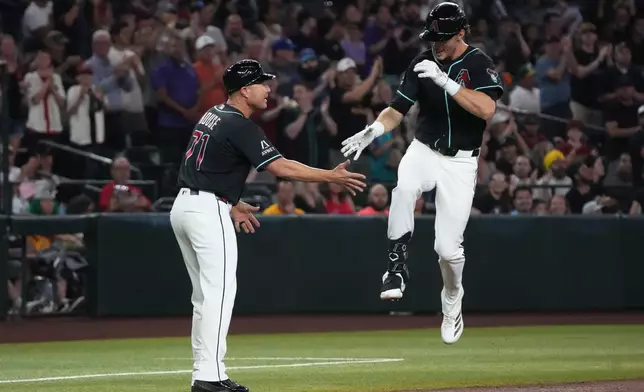 Arizona Diamondbacks' Max Kepler, right, celebrates with third base coach J.R. House (71) after hitting a three-run home run against the Athletics in the first inning of a baseball game, Tuesday, July 21, 2026, in Phoenix. (AP Photo/Rick Scuteri)