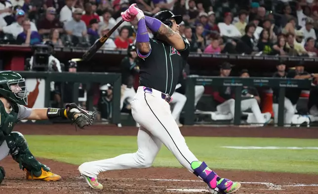 Arizona Diamondbacks' Ketel Marte hits an RBI sacrifice fly out against the Athletics in the seventh inning of a baseball game, Tuesday, July 21, 2026, in Phoenix. (AP Photo/Rick Scuteri)