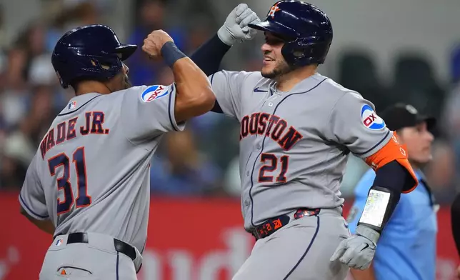 Houston Astros' Yainer Diaz (21) celebrates with teammate LaMonte Wade Jr. (31) after they both scored on a home run by Diaz during the seventh inning of a baseball game against the Texas Rangers, Friday, July 10, 2026, in Arlington, Texas. (AP Photo/LM Otero)