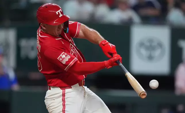 Texas Rangers' Wyatt Langford hits a home run during the 8th inning of a baseball game against the Houston Astros, Friday, July 10, 2026, in Arlington, Texas. (AP Photo/LM Otero)