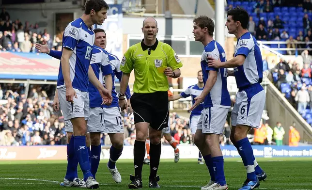 FILE - Birmingham City players protest a decision from referee Anthony Taylor, center, during their English Premier League soccer match against Blackpool at St. Andrews stadium in Birmingham, England, Oct. 23, 2010. (AP Photo/Simon Dawson, File)