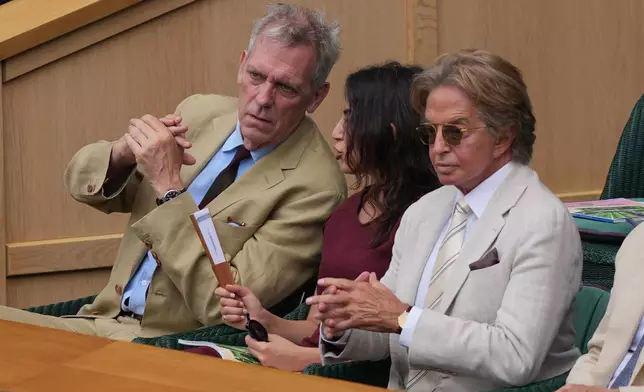 Actor Hugh Laurie, left, attends the royal box on day 12 of the Wimbledon Tennis Championships in London, Friday, July 10, 2026. (AP Photo/Kin Cheung)