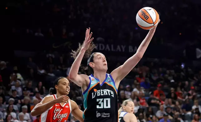 New York Liberty forward Breanna Stewart (30) makes a rebound ahead of Las Vegas Aces forward-center Brianna Turner (21) during the first half of an WNBA basketball game Thursday, July 30, 2026, in Las Vegas. (Steve Marcus/Las Vegas Sun via AP)