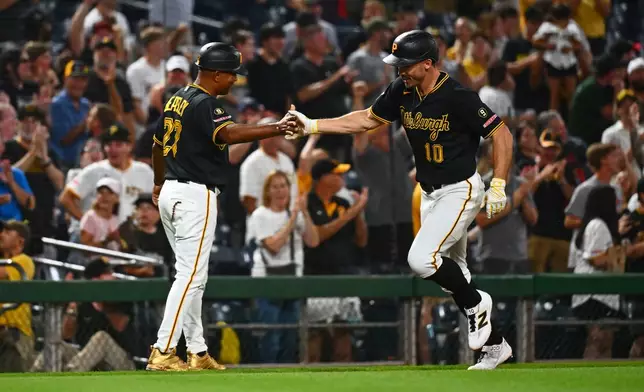 Pittsburgh Pirates' Bryan Reynolds celebrates with third base coach Tony Beasley after hitting a solo home run off of Arizona Diamondbacks pitcher Paul Sewald during the ninth inning of a baseball game in Pittsburgh, Tuesday, July 28, 2026. (AP Photo/Justin Berl)