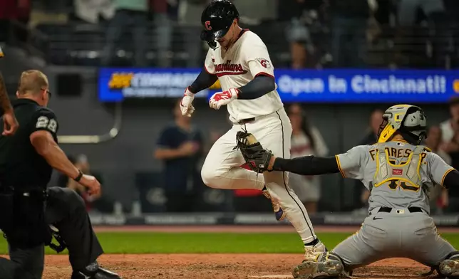Cleveland Guardians' Patrick Bailey, center, is tagged out by Pittsburgh Pirates catcher Rafael Flores Jr., right, at home plate in the ninth inning of the second baseball game of a split doubleheader in Cleveland, Saturday, June 18, 2026. (AP Photo/Sue Ogrocki)