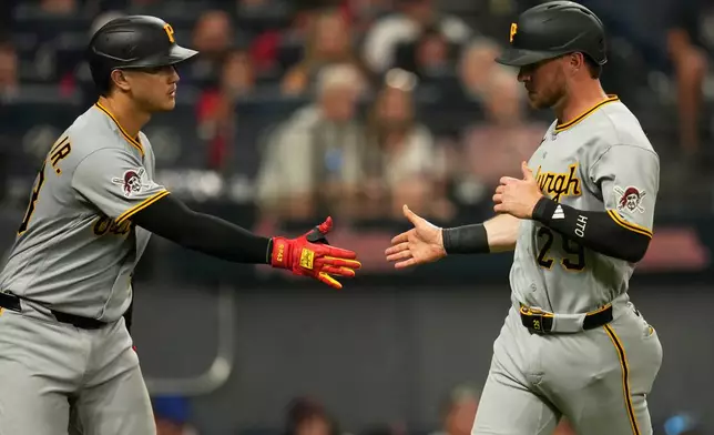 Pittsburgh Pirates' Ryan O'Hearn, right, is congratulated by Rafael Flores Jr., left, after scoring in the second inning of the second baseball game of a split doubleheader against the Cleveland Guardians in Cleveland, Saturday, June 18, 2026. (AP Photo/Sue Ogrocki)