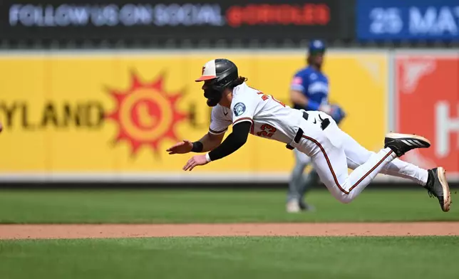 Baltimore Orioles' Blaze Alexander dives safely for second base after getting a late start on a popup lost in the sun to Kansas City Royals right fielder Jac Caglianone in the sixth inning of a baseball game Sunday, July 12, 2026, in Baltimore. (AP Photo/Gail Burton)