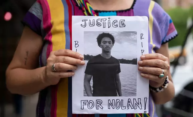 A person holds a picture of Nolan Xavier Wells during a news conference at National Action Network headquarters, Friday, July 10, 2026, in New York. (AP Photo/Yuki Iwamura)