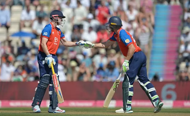 England's Jos Butler, right is congratulated by teammate Harry Brook after hitting a six during the international T20 Cricket match between England and India In Southampton, England, Saturday, July 11, 2026. (AP Photo/Anthony Upton)