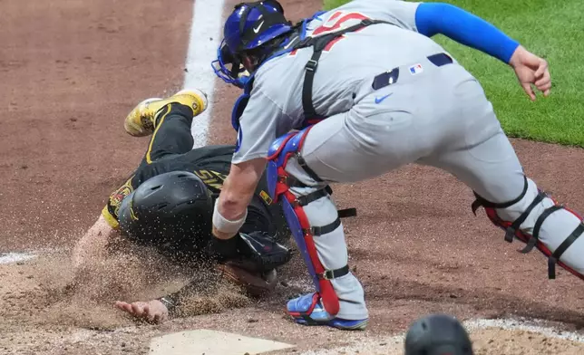 Chicago Cubs catcher Carson Kelly puts the tags out Pittsburgh Pirates' Henry Davis who was attempting to score on a sacrifice fly by Nick Gonzales during the seventh inning of a baseball game in Pittsburgh, Friday, July 24, 2026. (AP Photo/Gene J. Puskar)