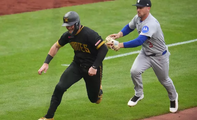 Chicago Cubs third baseman Alex Bregman (3) chases Pittsburgh Pirates' Henry Davis, left, to get an out during a third-inning rundown between third and home during a baseball game in Pittsburgh, Friday, July 24, 2026. (AP Photo/Gene J. Puskar)