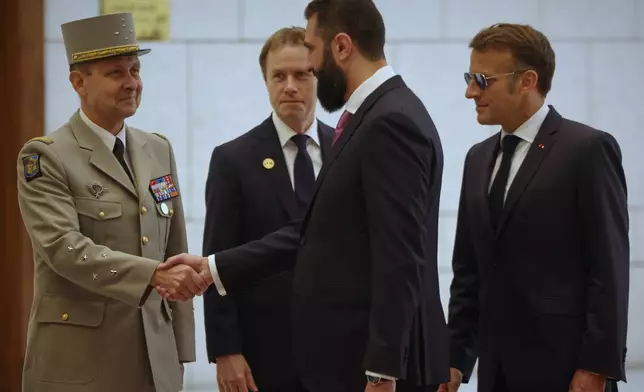 Syrian President Ahmad al-Sharaa, center, shakes hands with Gen. Vincent Giraud, Macron's Chief of Staff, as French President Emmanuel Macron, right, as they meet in Damascus, Syria, Tuesday, July 7, 2026. (AP Photo/Omar Albam)(AP Photo/Ghaith Alsayed)