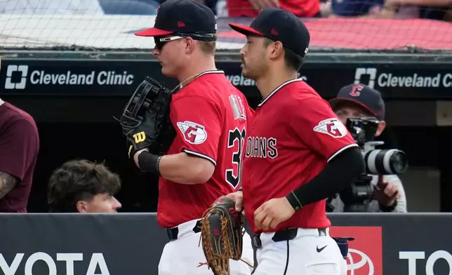 Cleveland Guardians left fielder Cooper Ingle, left, runs in from the outfield with center fielder Steven Kwan, right, after the first half of the seventh inning of a baseball game against the Texas Rangers in Cleveland, Tuesday, June 30, 2026. (AP Photo/Sue Ogrocki)