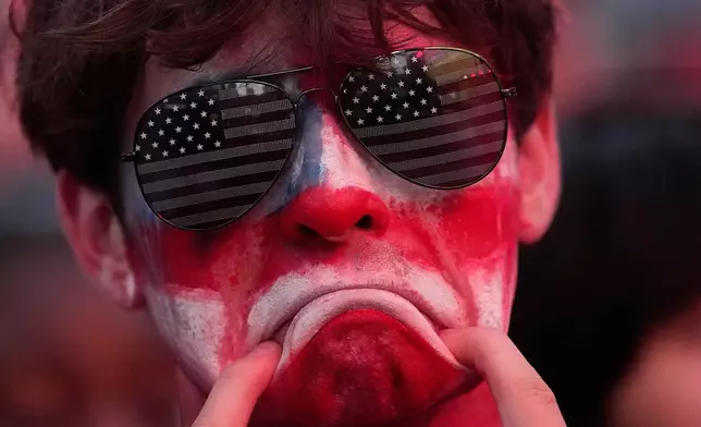 A fan reacts to a United States loss in a World Cup round of 16 soccer match against Belgium at the KC Live! entertainment district Monday, July 6, 2026, in Kansas City, Mo. (AP Photo/Charlie Riedel)