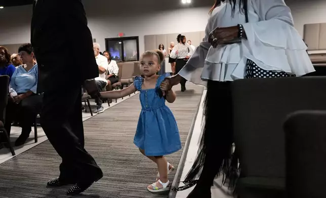 A young girl is among the attendees during a memorial service for Nolan Xavier Wells, an 18-year-old found dead after taking a July 4 boat trip with friends, Monday, July 20, 2026, in Ocean Springs, Miss. (AP Photo/Gerald Herbert)