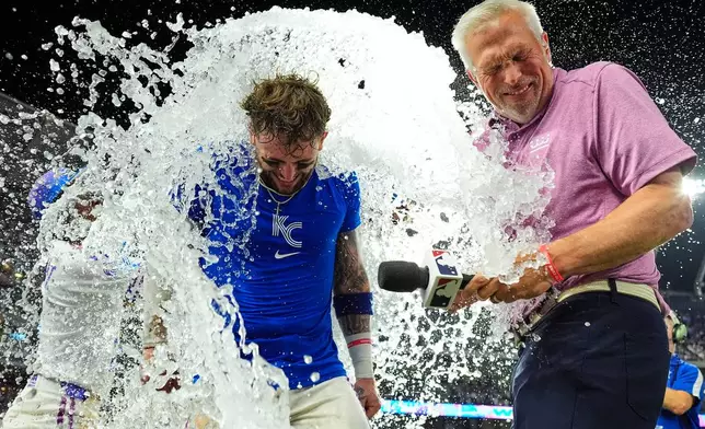 Kansas City Royals' Carter Jensen with commentator Joel Goldberg are doused by teammates after their baseball game, Friday, July 17, 2026, in Kansas City, Mo. (AP Photo/Charlie Riedel)