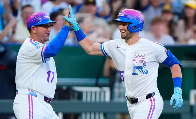 Kansas City Royals' Lane Thomas celebrates with third base coach Vance Wilson (17) after hitting a solo home run during the second inning of a baseball game against the San Diego Padres, Friday, July 17, 2026, in Kansas City, Mo. (AP Photo/Charlie Riedel)