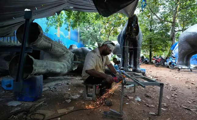 A worker welds parts to build a robotic elephant at a backyard workshop in Chalakudy, in the southern Indian state of Kerala, Friday, May 22, 2026. (AP Photo/Aijaz Rahi)