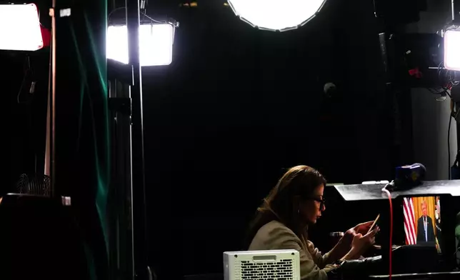 A reporter prepares to film a stand-up as President Donald Trump speaks from the East Room of the White House, Thursday, July 16, 2026, in Washington. (AP Photo/Julia Demaree Nikhinson)