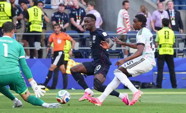 United States' Folarin Balogun (20) tries to score on Belgium goalkeeper Thibaut Courtois (1) during the World Cup round of 16 soccer match in Seattle, Monday, July 6, 2026. (AP Photo/Ted S. Warren)