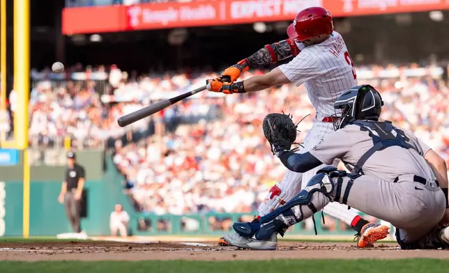 Philadelphia Phillies' Bryce Harper hits a sacrifice fly to score Trea Turner during the first inning of a baseball game against the New York Yankees, Saturday, July 25, 2026, in Philadelphia. (AP Photo/Chris Szagola)