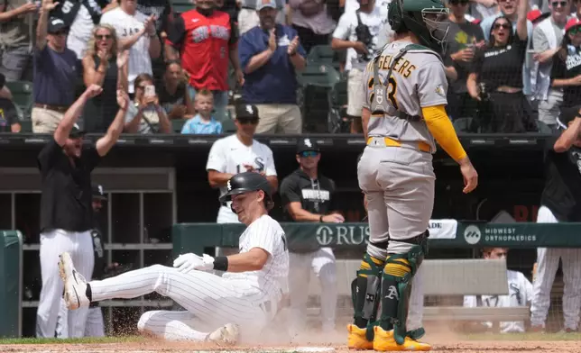 Chicago White Sox's Colson Montgomery, left, is safe at home plate as Athletics catcher Shea Langeliers, right, stands nearby during the sixth inning of a baseball game Saturday, July 11, 2026, in Chicago. (AP Photo/David Banks)