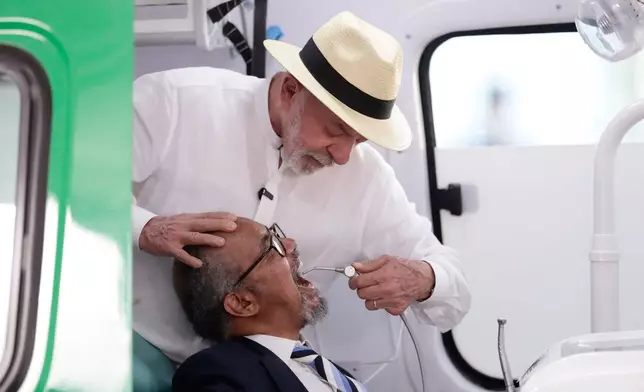 Brazilian President Luiz Inácio Lula da Silva pretends to examine World Health Organization Director-General Tedros Adhanom Ghebreyesus with dental equipment during a visit to the Andaraí Hospital in Rio de Janeiro, Brazil, Tuesday, July 28, 2026. (AP Photo/Bruna Prado)