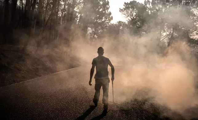 A man works to extinguish hot spots in an area burned by a wildfire near Casavieja, Ávila province, Spain, Wednesday, July 29, 2026. (AP Photo/Olmo Calvo)