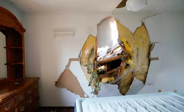 Debris is seen through the drywall of a bedroom after a tornado hit the day before in Menasha, Wis., Tuesday, July 28, 2026. (AP Photo/Kayla Wolf)