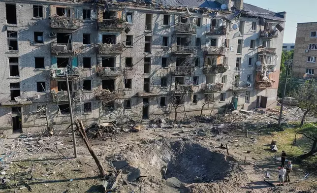 People look at the site of a Russian missile strike that hit a residential building in Kyiv, Ukraine, Thursday, July 2, 2026. (AP Photo/Efrem Lukatsky)