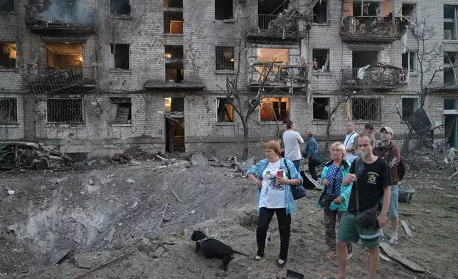 People look at the site of a Russian missile strike that hit a residential building in Kyiv, Ukraine, Thursday, July 2, 2026. (AP Photo/Danylo Antoniuk)