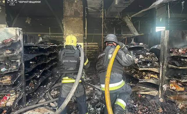 In this photo provided by the Ukrainian Emergency Service, firefighters put out a fire in a supermarket following a Russian drone attack in Chernihiv, Ukraine, Sunday, July 26, 2026. (Ukrainian Emergency Service via AP)