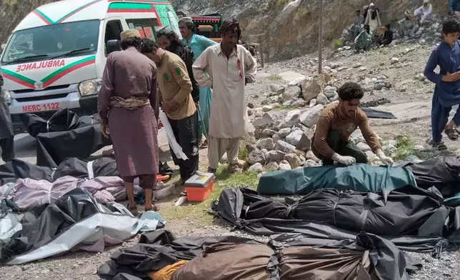 Rescue workers and volunteers cover bodies after recovering them after an overcrowded passenger bus plunged from a highway into a rocky ravine, in Dana Sar, a remote area near the border of Balochistan and Khyber Pakhtunkhwa provinces, in southwestern Pakistan, Friday, July 3, 2026. (AP Photo/Zain Ullah)