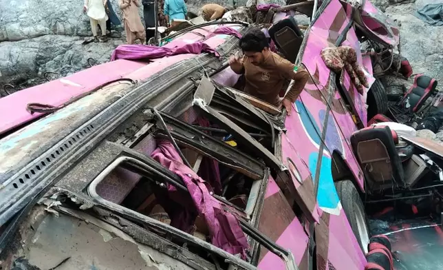 In this photo released by Balochistan Emergency Services Department, soldiers and volunteers take part in a rescue work at the site of an overcrowded passenger bus plunged from a highway into a rocky ravine, in Dana Sar, a remote area near the border of Balochistan and Khyber Pakhtunkhwa provinces, in southwestern Pakistan, Friday, July 3, 2026. (Balochistan Emergency Services Department via AP)