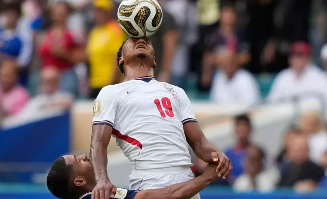 England's Ollie Watkins (19) heads the ball challenged by France's Maxence Lacroix (26) during the World Cup third-place playoff soccer match between France and England in Miami Gardens, Fla., Saturday, July 18, 2026. (AP Photo/Lynne Sladky)