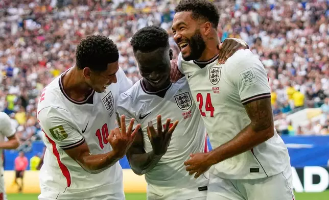England's Bukayo Saka (7) is congratulated by Jude Bellingham (10) and Reece James (24) after scoring his side's 5th goal from the penalty spot during the World Cup third-place playoff soccer match between France and England in Miami Gardens, Fla., Saturday, July 18, 2026. (AP Photo/Lynne Sladky)