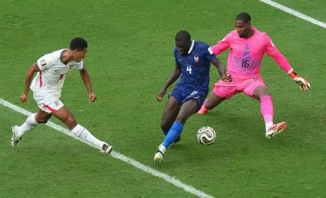England's Jude Bellingham (10) shoots the ball past France's Dayot Upamecano (4) and goalkeeper Mike Maignan (16) to score their sixth goal during the World Cup third-place playoff soccer match between France and England in Miami Gardens, Fla., Saturday, July 18, 2026. (AP Photo/Marta Lavandier)